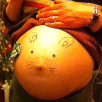 A pregnant naked bump where a little rabbit has been drawn using the belly botton as nose