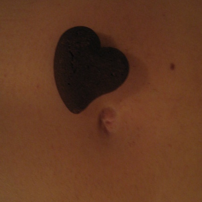 Belly botton with a chocolate heart shaped biscuit next to it